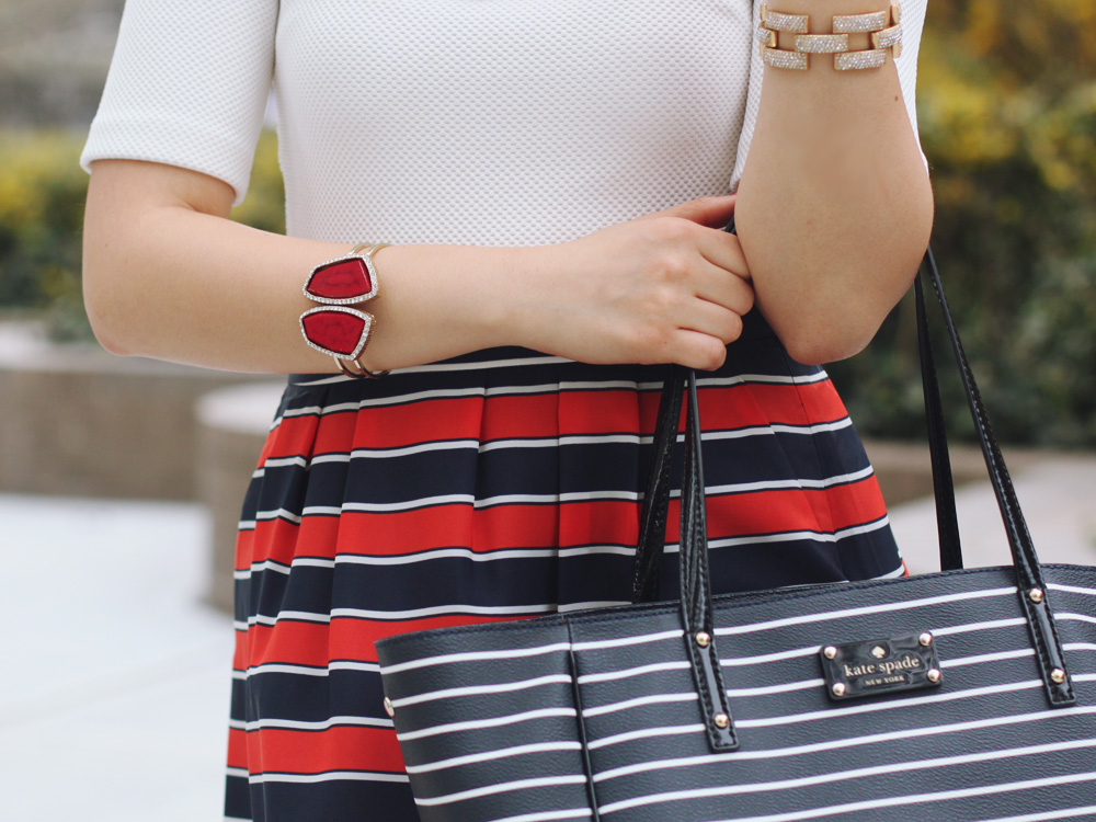 Skirt The Rules Blog; NYC fashion blogger; style blog; spring outfit photos; H&M cream structured shoulder top; J.Crew Factory red and navy striped skirt; Juicy Couture statement necklace; gemstone cuff bracelet; Kate Spade City Sidney Striped tote bag; Pour La Victoire Mai wedge; J.Crew pave square link bracelet